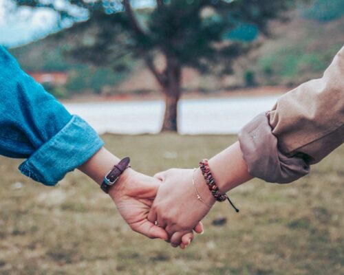 two persons holding hands