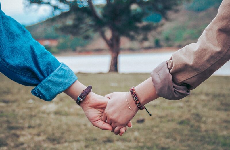 two persons holding hands